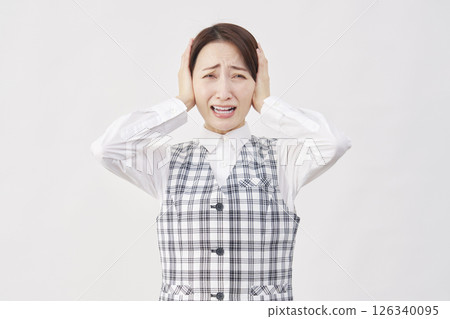 Female office worker covering her ears white background 126340095