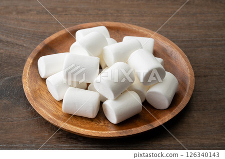 White marshmallows on a wooden plate White marshmallows on a wooden plate 126340143