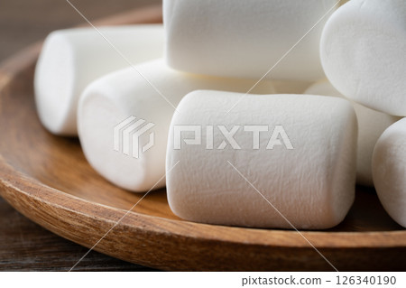 Close-up of white marshmallows on a wooden plate Close-up of white marshmallows on a wooden plate 126340190