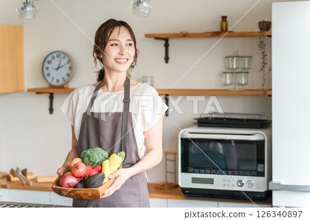 Asian woman holding vegetables in the kitchen, housewife Asian woman holding vegetables in the kitchen, housewife 126340897