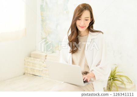 A woman operating a laptop computer on her lap 126341111