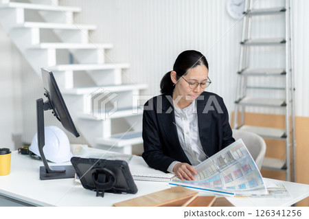 A female employee checking construction documents A female employee checking construction documents 126341256