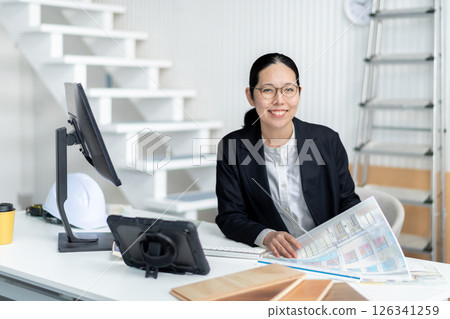 A female employee checking construction documents A female employee checking construction documents 126341259