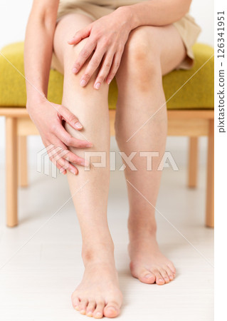 A middle-aged woman in summer clothes who is concerned about her leg body care A middle-aged woman in summer clothes who is concerned about her leg body care 126341951