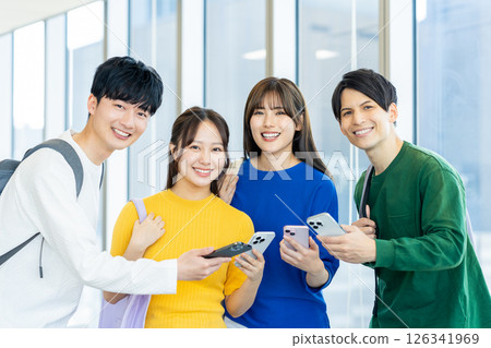 Male and female university students looking at their smartphones. Photo courtesy of Denpa Gakuen, Tokyo Electronics College. 126341969