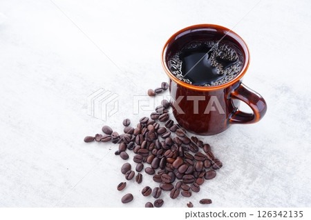 A mug of freshly brewed aromatic coffee and dark roasted coffee beans A mug of freshly brewed aromatic coffee and dark roasted coffee beans 126342135
