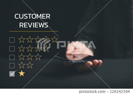 Expressing dissatisfaction through a 1-star satisfaction rating on social media using a smartphone. Negative feedback concept impacting business reputation and customer opinion. Expressing dissatisfaction through a 1-star satisfaction rating on social media using a smartphone. Negative feedback concept impacting business reputation and customer opinion. 126342594
