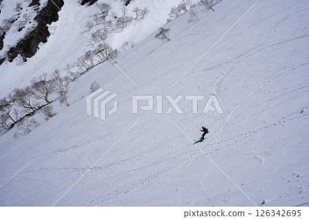 Backcountry skiers skiing down the spring snowfields of Mt. Harinoki 126342695