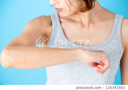 一位身穿背心的中年女性擔心自己腋下的體味 126342983