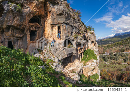 Happy family visiting ancient Greek city Tlos in Lycia located on Lycian way  Famous historical and archeological site. Popular place for family travel on summer vacation. Fethiye, Mugla, Turkey 126343341