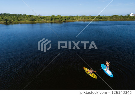 Active kids have a fun on kayak and stand up paddle SUP board in sea lagoon. Healthy lifestyle. Recreational water sport, SUP tour in adventure camp on family summer beach vacation 126343345