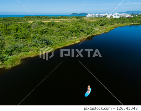 Happy mother with child have a fun on stand up paddle SUP board in sea lagoon. Healthy lifestyle. Recreational water sport, SUP tour in adventure camp on family summer beach vacation 126343348