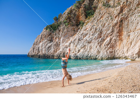 Happy boy having fun at Kaputas beach with turquoise sea water, Lycia coast. Summer relaxing day at family vacation in Mediterranean Sea, Kas, Antalya region, Turkey Happy boy having fun at Kaputas beach with turquoise sea water, Lycia coast. Summer relaxing day at family vacation in Mediterranean Sea, Kas, Antalya region, Turkey 126343467
