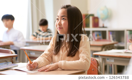 Elementary school girl concentrating in class Elementary school girl concentrating in class 126343788
