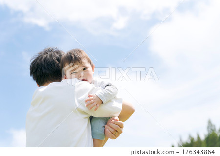 Baby boy being held by his father 126343864