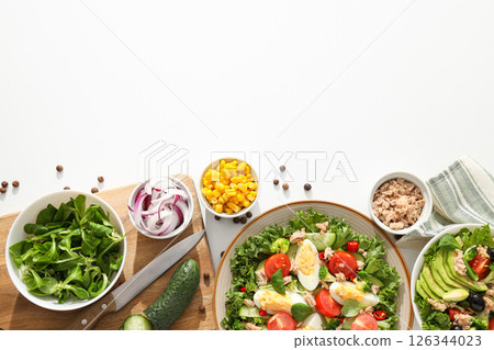 Cooking salad with tuna on a light background. 126344023