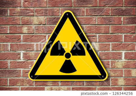 Radioactive caution warning sign on a brick wall background 126344256