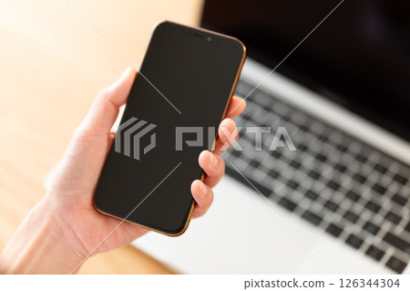 Middle-aged woman's hand holding a smartphone 126344304