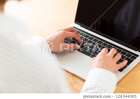 Hands of a middle-aged woman operating a laptop 126344305