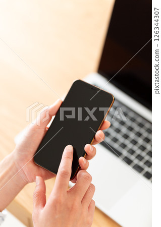 Middle-aged woman's hand holding a smartphone Middle-aged woman's hand holding a smartphone 126344307