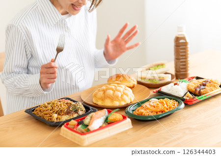 Middle-aged woman eating a lot 126344403