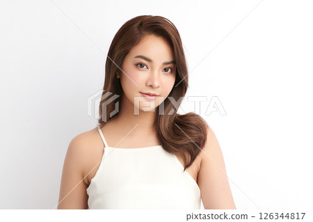 A beautiful young Asian woman with clean, fresh skin against a white background. Skincare, facial treatment, cosmetology, beauty, and spa. An elegant portrait of an Asian woman. 126344817