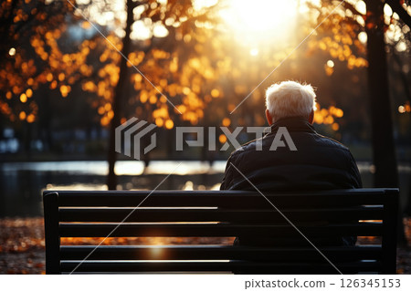 Old man sitting lonely on bench in autumn lake park. 126345153