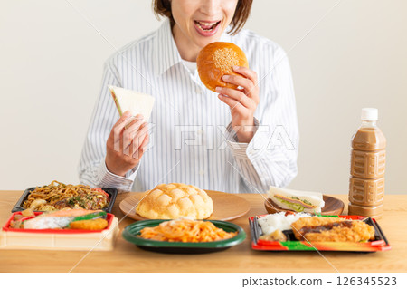 Middle-aged woman eating a lot Middle-aged woman eating a lot 126345523