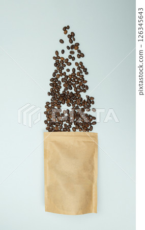 Scattered coffee beans from kraft paper bag, blue background, Top view. Flat lay Scattered coffee beans from kraft paper bag, blue background, Top view. Flat lay 126345643