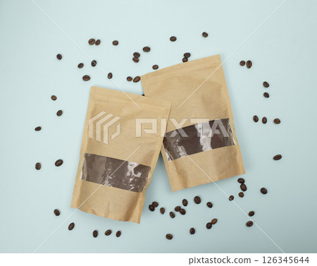 Paper eco bags with freshly ground coffee and coffee beans on a blue background. Top view. Flat lay. Paper eco bags with freshly ground coffee and coffee beans on a blue background. Top view. Flat lay. 126345644