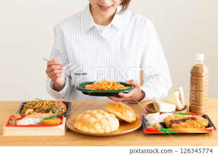 Middle-aged woman eating a lot 126345774