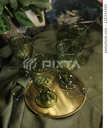 elegant green drinking set of glasses on a golden tray 126345894
