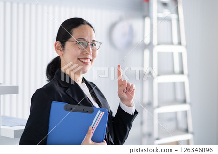 A smiling female architect signing a one-point signature A smiling female architect signing a one-point signature 126346096