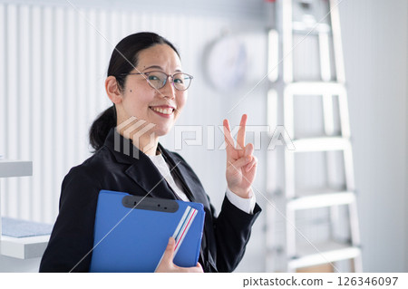 A smiling female architect signing a one-point signature A smiling female architect signing a one-point signature 126346097