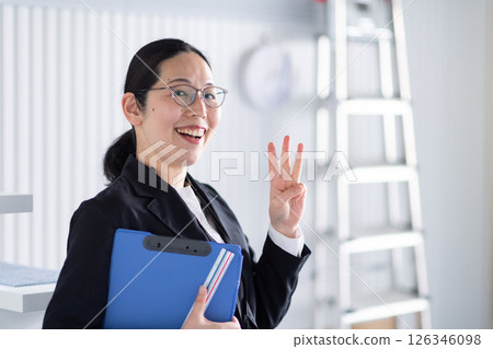 A smiling female architect signing a one-point signature A smiling female architect signing a one-point signature 126346098