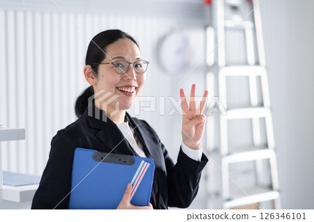 A smiling female architect signing a one-point signature A smiling female architect signing a one-point signature 126346101
