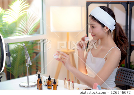 Young asian woman presenting and review cosmetic product with excitement on social media. 126346672