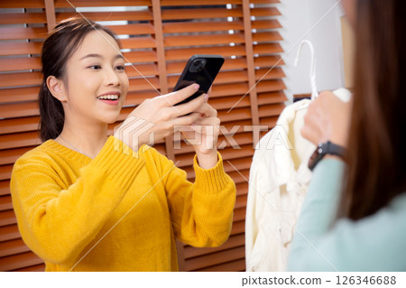 Two asian woman taking picture of clothes for online store. 126346688
