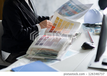 A woman's hands checking wallpaper samples A woman's hands checking wallpaper samples 126346737