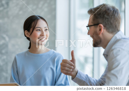 A woman taking an English conversation lesson with a foreign teacher Generative AI 126346818