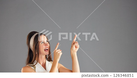 Excited, woman and pointing up to space for advertising, mockup or discount deal. Happy person, marketing and presentation in studio for retro fashion sales, promotion or offer on gray background Excited, woman and pointing up to space for advertising, mockup or discount deal. Happy person, marketing and presentation in studio for retro fashion sales, promotion or offer on gray background 126346851