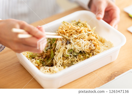 Hands of a middle-aged woman preparing cup noodles Hands of a middle-aged woman preparing cup noodles 126347136