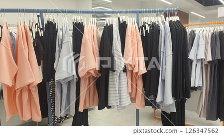 Clothes hanging on hangers in a retail store showcasing fashion and style 126347562