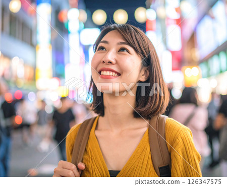 晚上在市中心散步的女人 晚上在市中心散步的女人 126347575