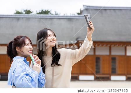 A woman taking a picture with a smartphone A woman taking a picture with a smartphone 126347825