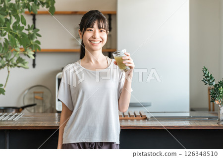 亞洲年輕女性在家客廳訓練後補充水分和營養 126348510