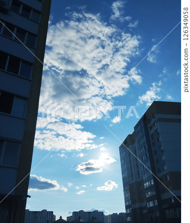 Blue sky with white clouds on a sunny day between houses. Cityscape Blue sky with white clouds on a sunny day between houses. Cityscape 126349058