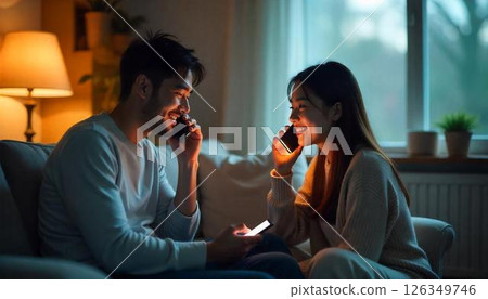 A couple talking on a smartphone while standing nearby 126349746