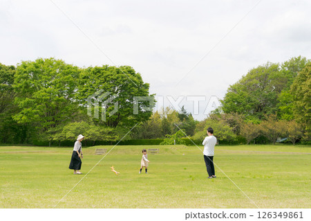 Family playing in a large field Family playing in a large field 126349861