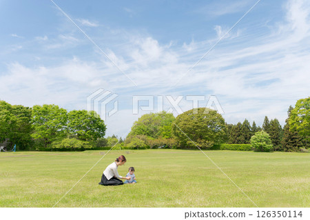 Parent and child playing in the park 126350114